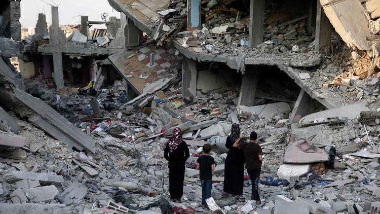 Des Palestiniens déambulent le 17 août 2014 dans les décombres de la bande de Gaza [Thomas Coex / AFP]