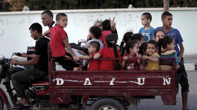 Des Gazaouis fuient le quartier périphérique de Chajaya et se dirigent vers une école de l'ONU, le 19 août 2014 [Thomas Coex / AFP/Archives]