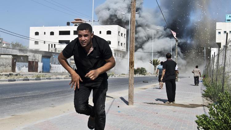 Un Palestinien fuit les frappes israéliens le 23 août 2014 à Gaza [Roberto Schmidt / AFP]