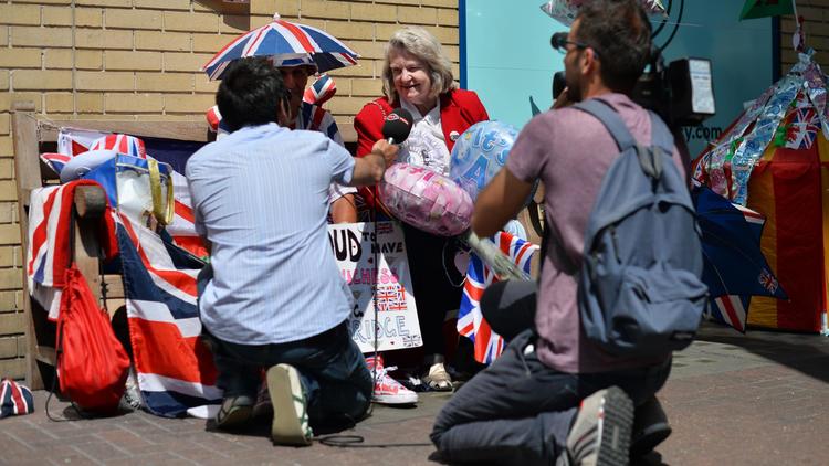 Une équipe de journalistes interviewent une Britannique qui patiente devant l'hôpital St Mary à Londres, le 18 juillet 2013 [Ben Stansall / AFP]