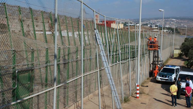 Des techniciens réparent les grilles faisant office de frontière entre l'Espagne et le Maroc à Melilla, le 17 septembre 2013 [- / Gouvernement régional de Melilla/AFP]