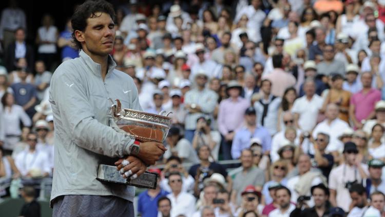 L'Espagnol Rafael Nadal savoure sa 9e victoire à Roland-Garros, le 8 juin 2014 [Dominique Faget / AFP]