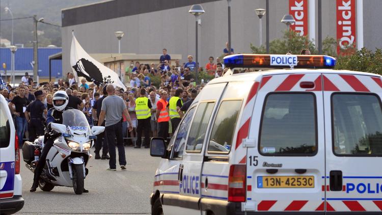 Des policiers tiennent éloignés des supporteurs lors de la rencontre entre Bastia et Marseille, le 9 août 2014 aux abords du stade Armand Cesari à Bastia, en Corse. [Pascal Pochard Casabianca / AFP/Archives]
