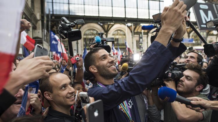 Mahiédine Mekhissi se photographie avec des fans, le 18 août 2014 à la gare de Lyon à Paris [Fred Dufour / AFP]