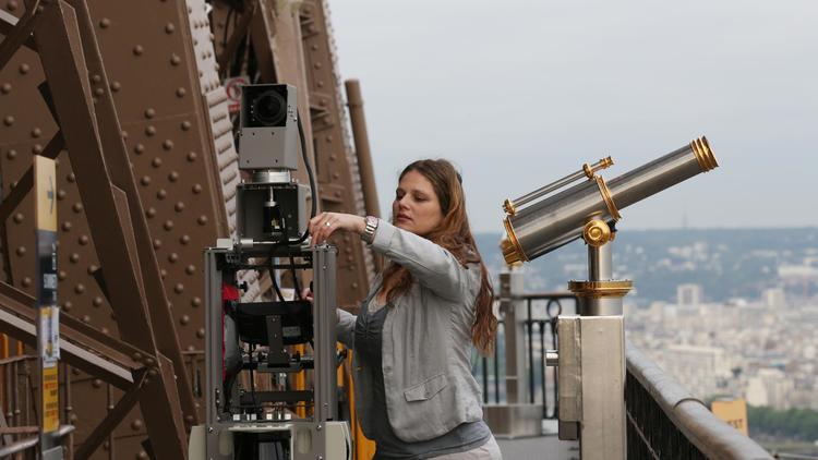 Une employée de Google prépare la caméra qui prendra des photos panoramiques du haut de la Tour Eiffel, le 6 juillet 2013 [THOMAS SAMSON / AFP Photo]