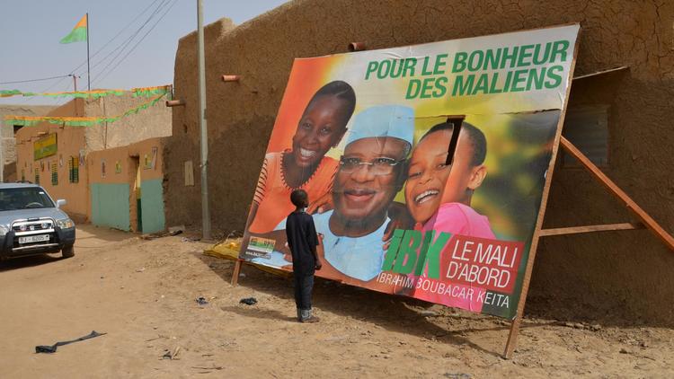Un garçon regarde une affiche de la campagne présidentielle, le 22 juillet 2013 à Gao [Boureima Hama / AFP]