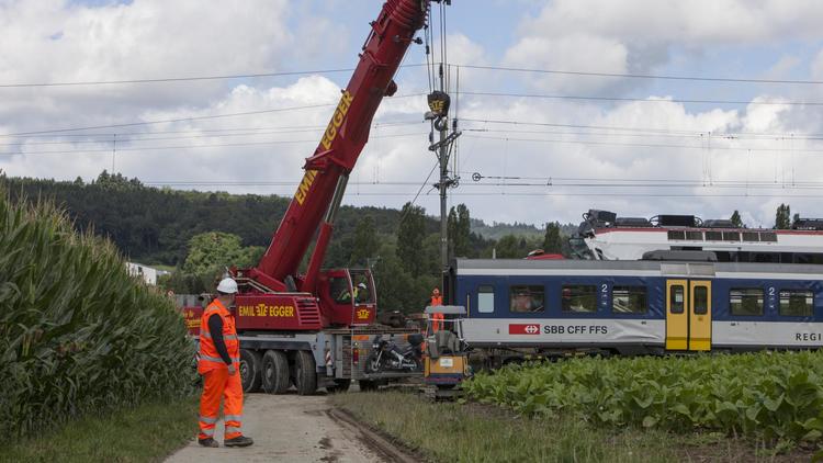 Des ouvriers travaillent sur le site de la collision ferroviaire survenue la veille à Granges-Près-Marnand, dans l'ouest de la Suisse, le 30 juillet 2013 [Boris Heger / AFP]