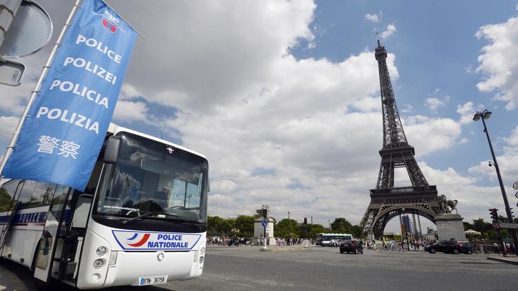 Un car de police garé devant la Tour Eiffel, à Paris le 14 août 2013 [Miguel Medina / AFP]