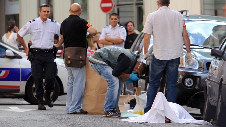 Experts et policiers autour du corps de l'homme abattu par un bijoutier le 11 septembre 2013 à Nice [Jean-Christophe Magnenet  / AFP]