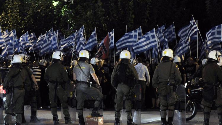 Des partisans d'Aube dorée face à la police devant le tribunal d'Athènes, le 2 octobre 2013 [Louisa Gouliamaki / AFP]