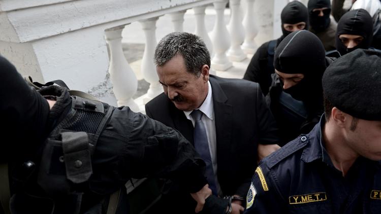 Le député d'Aube dorée Christos Pappas escorté vers le tribunal d'Athènes où il doit comparaître devant un juge d'instruction, le 3 octobre 2013 [Aris Messinis / AFP]