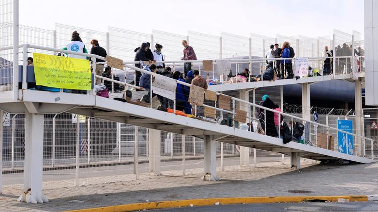 Des migrants syriens installés sur une passerelle piétonne du terminal ferry de Calais le 3 octobre 2013 [Philippe Huguen / AFP]