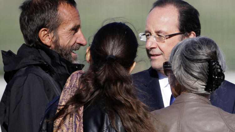 L'ex-otage Daniel Larribe accueilli par ses proches et par François Hollande à son arrivée le 30 octobre 2013 à l'aéroport militaire de Villacoublay [Kenzo Tribouillard / AFP]