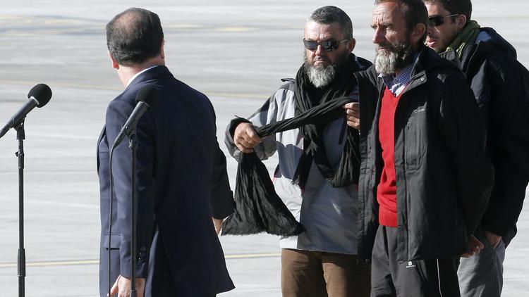 Les otages libérés, dont Daniel Larribe (en pullover rouge), avec le président de la République à l'aéroport de Villacoublay, le 30 octobre 2013 [François Guillot / AFP/Archives]