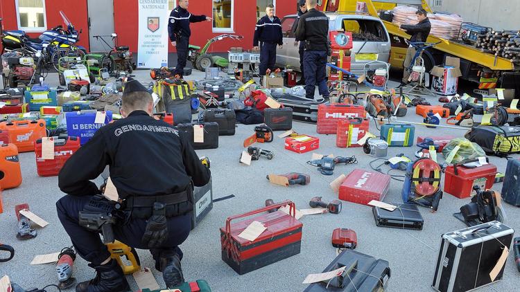 Des gendarmes examinent des objets saisis dans un campement rom à Montpellier et suspectés d'avoir été volés, le 14 novembre 2013 [Pascal Guyot / AFP]