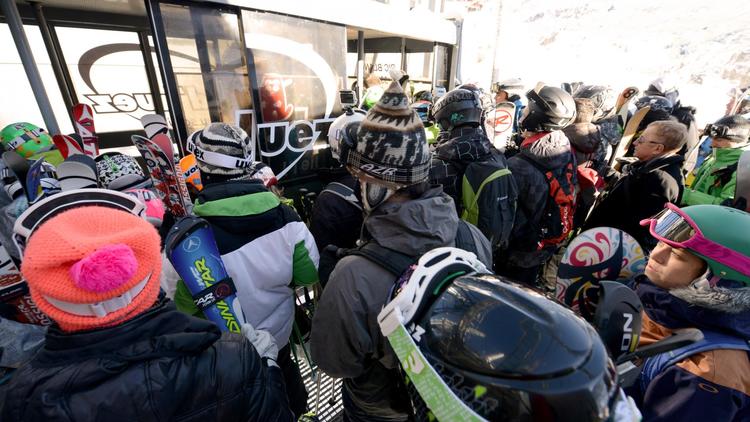 Des skieurs prennent le téléphérique dans la station de l'Alpe d'Huez (Isère), le 16 novembre 2013 [Jean-Pierre Clatot / AFP]