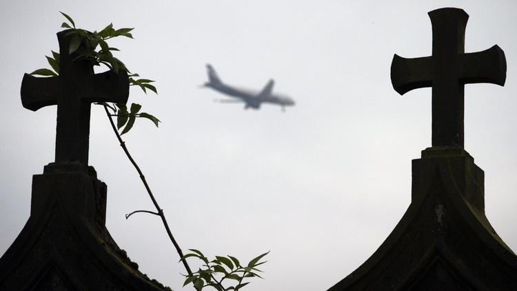 Un avion survole le 26 novembre 2013 le cimetière de Goussainville, près de l'aéroport de Paris-Roissy [Joël Saget / AFP]