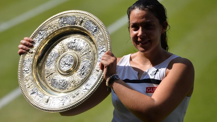 La Française Marion Bartoli soulève le trophée du tournoi de Wimbledon après avoir battu en finale l'Allemande Sabine Lisicki, le 6 juillet 2013 à Londres [ / AFP/Archives]