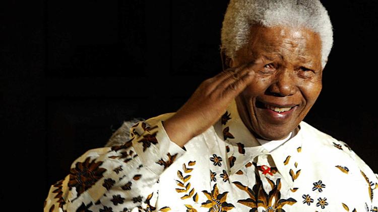 L'ancien président sud-africain Nelson Mandela salue une fanfare militaire à l'occasion de son 85e anniversaire à Johannesburg, le 18 juillet 2003 [Alexander Joe / AFP/Archives]