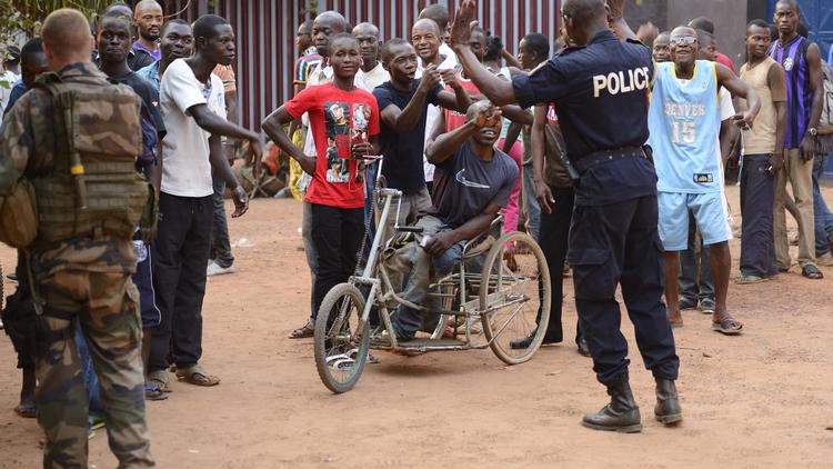 Un officier de police centrafricain et un soldat français contiennent la foule à Bangui le 17 janvier 2014 [Eric Feferberg / AFP]