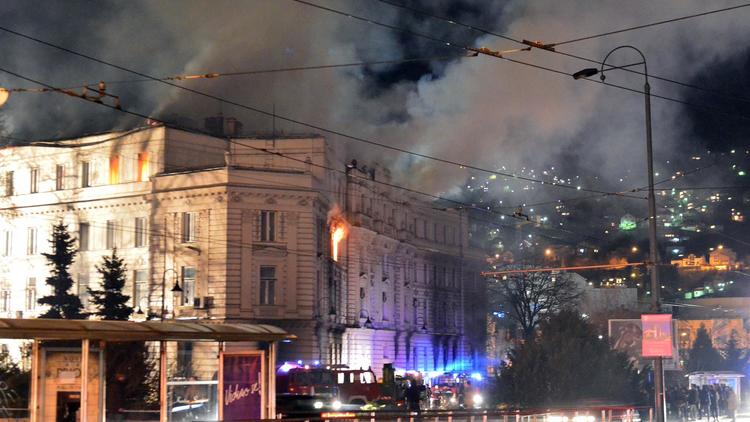 Des pompiers tentent d'éteindre l'incendie d'un bâtiment officiel à Sarajevo le 7 février 2014 [Elvis Barukcic / AFP]
