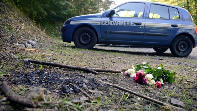 Un bouquet de roses déposé devant une voiture de la gendarmerie à la suite de la tuerie de Chevaline le 8 septembre 2012 [Philippe Desmazes / AFP]