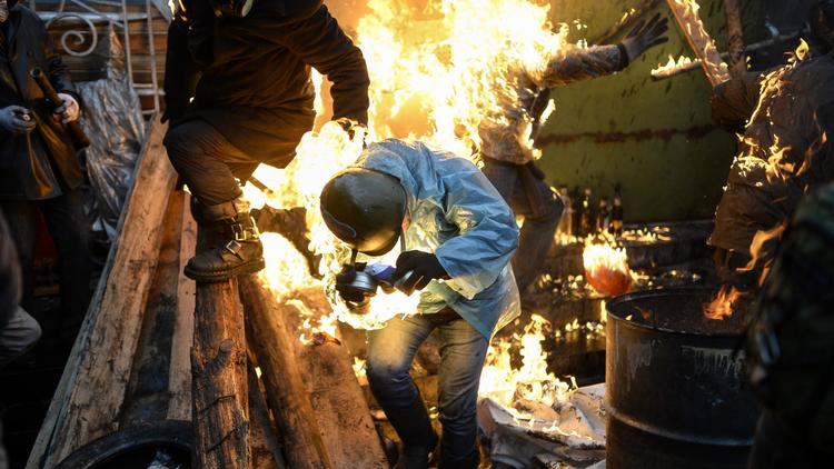 Des manifestants touchés par le feu sur les barricades lors des affrontements avec la police à Kiev le 20 février 2014 [Bulent Kilic / AFP]