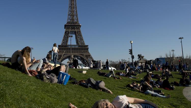 Des promeneurs devant la Tour Eiffel le 9 mars 2014 à Paris [Alain Jocard / AFP]