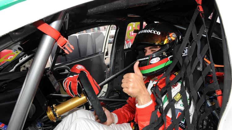 Le pilote marocain de WTCC Mehdi Bennani s'installe au volant de sa Honda Civic avant de se lancer dans la course disputée sur le circuit de Marrackech, le 13 avril 2014  [ / AFP]
