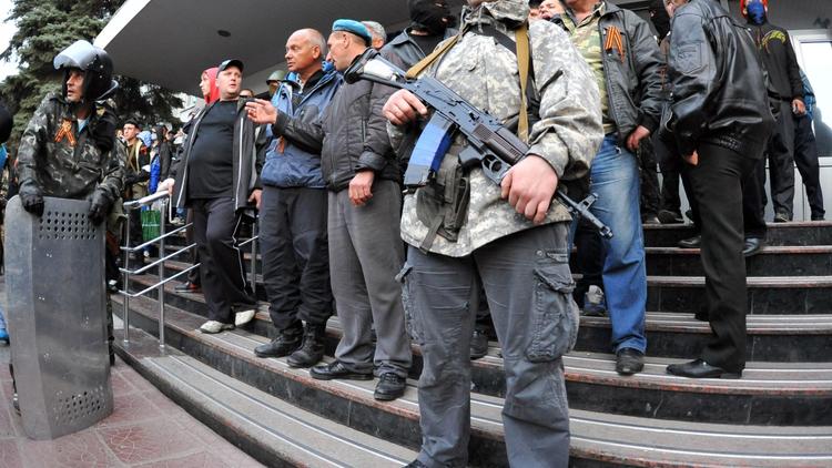 Des miliciens pro-russes montent la garde devant le QG de la police à Lougansk, dans l'est du pays, le 29 avril 2014 [Alex Inoy / AFP]