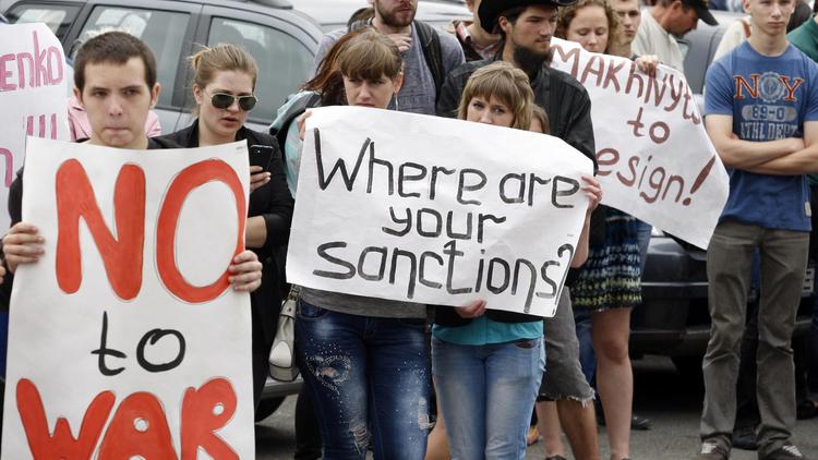 Manifestants devant le siège de la délégation de l'UE à Kiev: "Non à la guerre", "Où sont vos sanctions ?", demandent les protestataires aux dirigeants européens, le 30 mai 2014 [Yuriy Kirnichny / AFP]