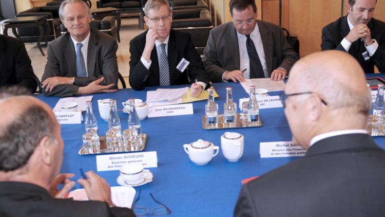 Le ministre des Finances Michel Sapin (de dos, à droite) mardi 24 juin 2014 lors d'une rencontre à Paris entre les patrons de banques françaises et suisses [Eric Piermont / AFP]