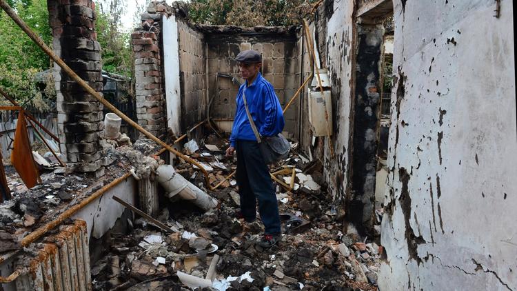 Un homme regarde, impuissant, les décombres de sa maison détruite par les bombardements dans la ville assiégée de Slaviansk le 24 juin 2014 [John MacDougall / AFP/Archives]