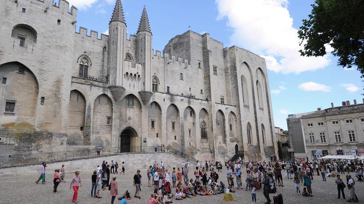 Des artistes du festival "off" promeuvent leurs spectacles devant le palais de papes, à Avignon, le 8 juillet 2014 [Boris Horvat  / AFP/Archives]