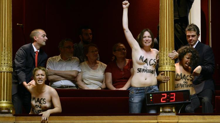Des Femen seins nus crient "Etes-vous macs ou sénateurs ?", le 17 juillet 2014 au Sénat [Bertrand Guay / AFP]