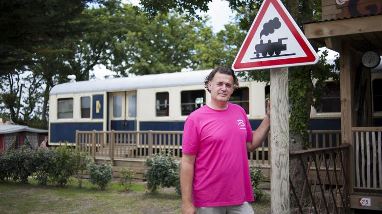 Guillaume Staub, le propriétaire du camping de Saint-Michel-Chef-Chef, pose devant un wagon de train le 15 juillet 2014 [Jean-Sébastien Evrard / AFP]
