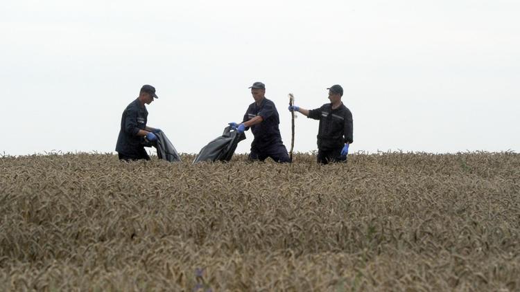 Des secouristes ukrainiens ramassent les corps des victimes du vol MH17 à Grabove, en Ukraine, le 19 juillet 2014 [Dominique Faget / AFP]