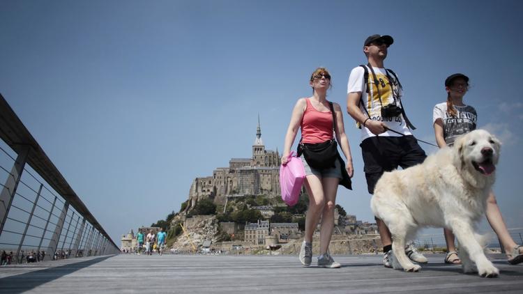 Des touristes sur le pont-passerelle menant au Mont-Saint-Michel (Manche), le 22 juillet 2014 [Charly Triballeau / AFP]
