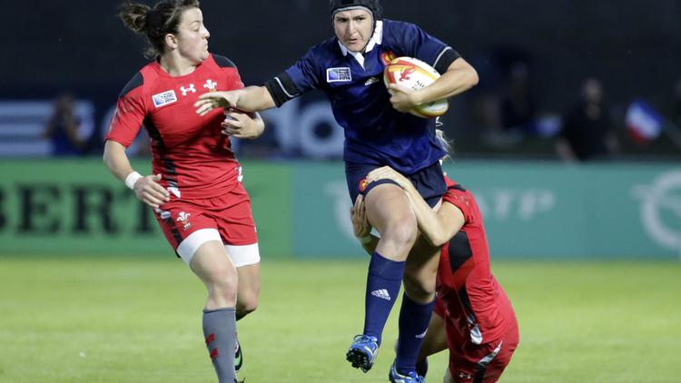 La Française Shannon Izar tente d'échapper au plaquage de deux joueuses galloises lors d'une rencontre comptant pour la Coupe du Monde de rugby féminin, le 1er août 2014 à Marcoussis, dans l'Essonne. [Kenzo Tribouillard / AFP/Archives]