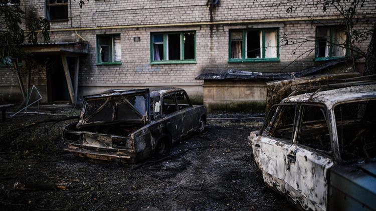 Des voitures carbonisées le 12 août 2014 après le bombardement de la ville de Yassynouvata, près de Donetsk, dans l'est de l'Ukraine [Dimitar Dilkoff / AFP]