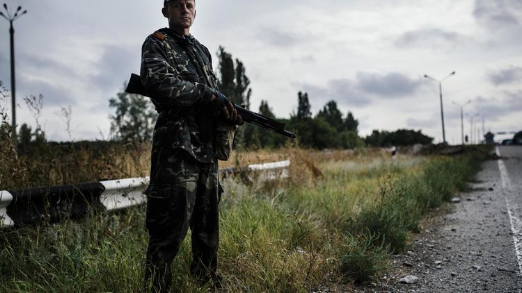 Un rebelle pro-russe le 18 août 2014 sur une route près de Donetsk [Dimitar Dilkoff / AFP]