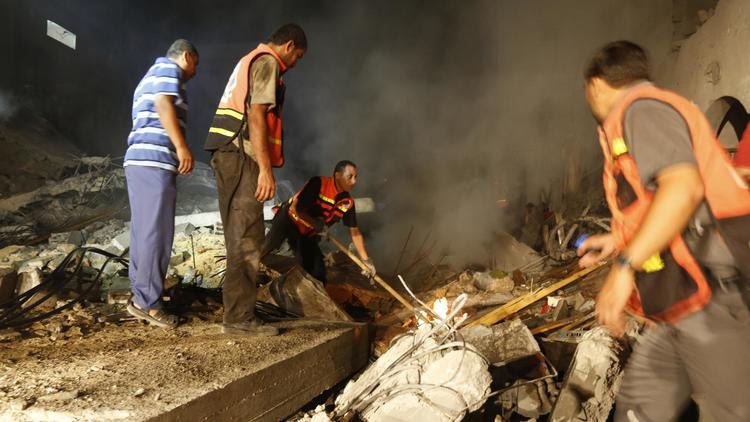 Des Palestiniens dans les ruines d'une maison détruite par un tir israélien le 19 août 2014 à Gasa [Mohammed Abed / AFP]