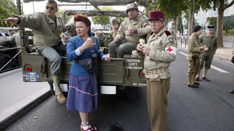 Des Parisiens portent les vêtements des soldats de la deuxième guerre mondiale à Paris le 23 août 2014 à l'occasion du 70e anniversaire de la Libération de Paris [Patrick Kovarik / AFP]