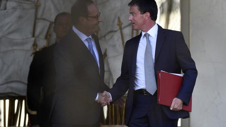 Le Premier ministre Manuel Valls (d) salue le président François Hollande alors qu'il quitte l'Elysée à Paris après une réunion pour la nomination du nouveau gouvernement le 26 août 2014 [Martin Bureau / AFP]