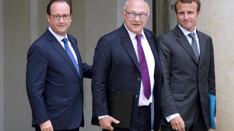 François Hollande avec son ministre des Finances Michel Sapin (c) et le nouveau ministre de l'Economie Emmanuel Macron (d), à la sortie du Conseil des ministres, le 27 août 2014 [Bertrand Guay / AFP]