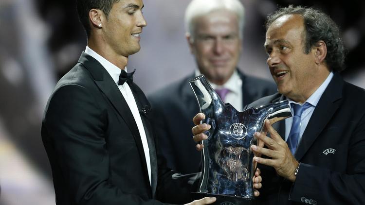 La star du Real Madrid Cristiano Ronaldo (g) reçoit des mains du président de l'UEFA Michel Platini son trophée de meilleur joueur de l'année 2013-2014, le 28 août 2014 à Monaco [ / AFP]