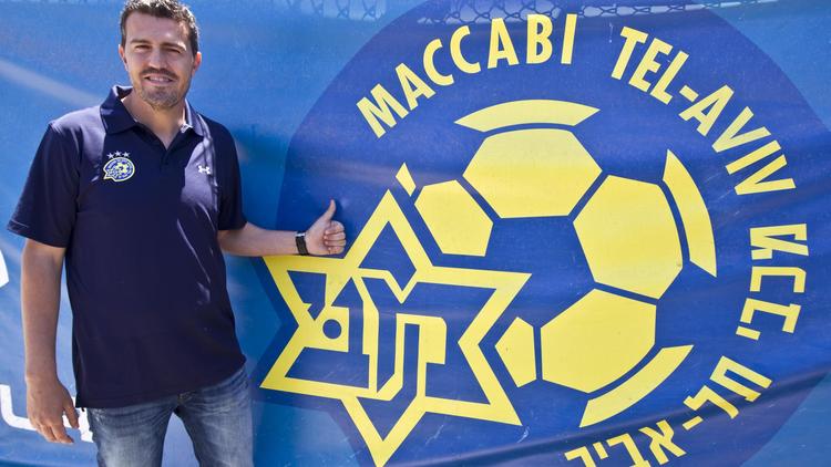 Oscar Garcia l'entraîneur du Maccabi Tel Aviv FC devant le logo de son club le 31 mai 2012 à Tel-Aviv [Jack Guez / AFP/Archives]