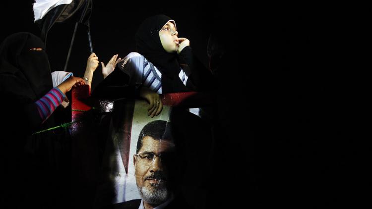 Un partisan des Frères musulmans tient le portrait du président destitué Mohamed Morsi, lors d'un rassemblement le 7 juillet 2013 au Caire [Mahmoud Khaled / AFP/Archives]