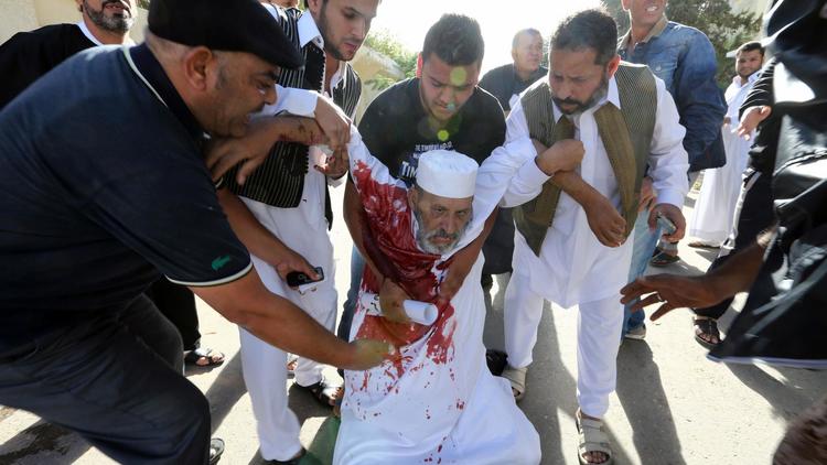 Un homme blessé lors d'une manifestation est secouru le 15 novembre 2013 à Tripoli [Mahmud Turkia / AFP]