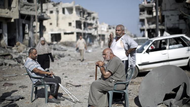 Des Palestiniens dans une rue dévastée de Gaza, le 1er août 2014  [Mahmud Hams / AFP]